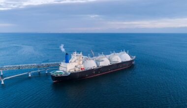 An LNG (liquefied natural gas) carrier is docked at a marine terminal during the offloading process in open waters. (Adobe Stock Photo)