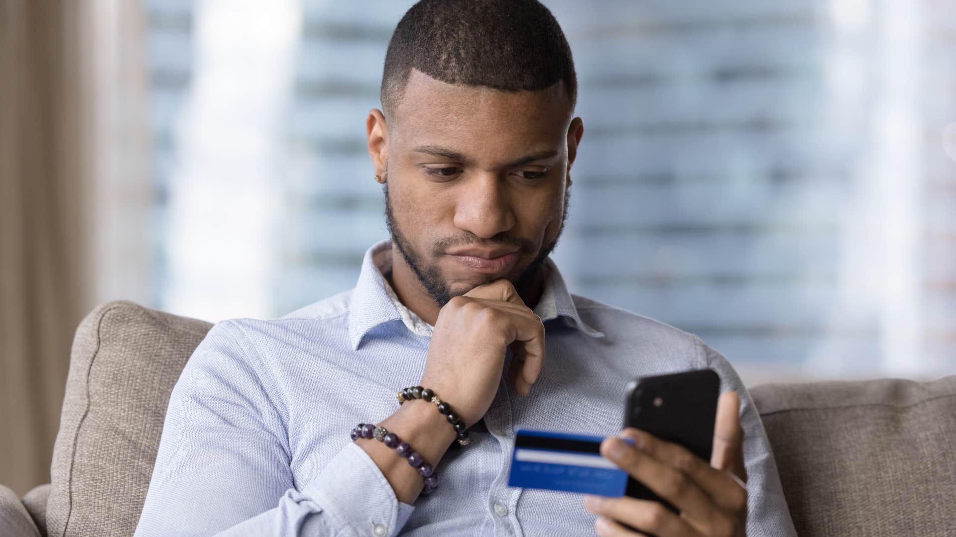 man looking at overpriced extended warranties on his phone