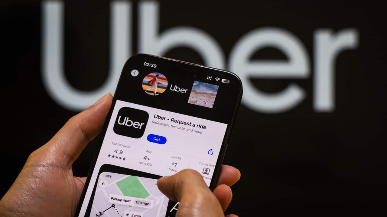 A person looking at the Uber app on a smartphone.