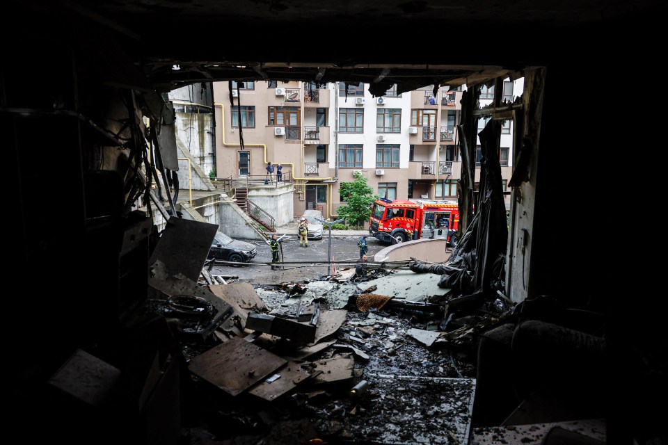 View from a destroyed apartment showing fire damage and emergency responders outside.