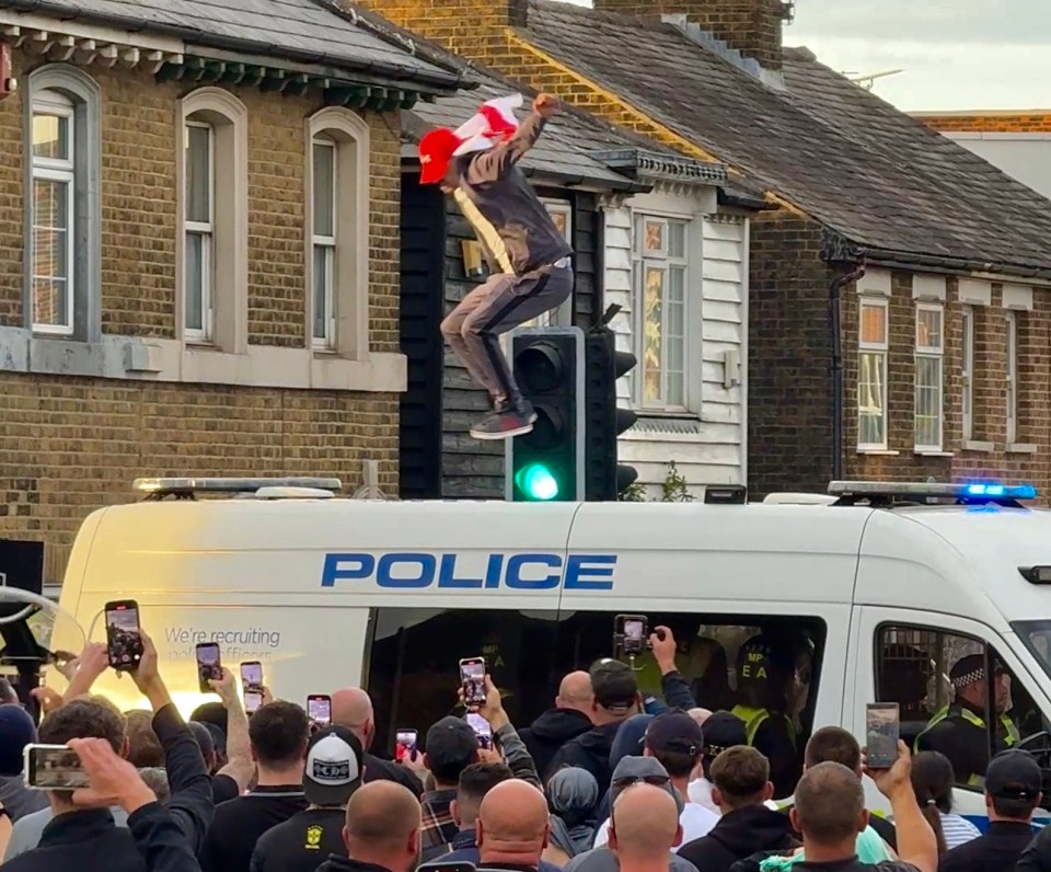 Protestor jumping onto a police van during a demonstration.