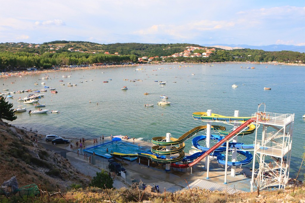 Aerial view of a water park with slides near a beach and sea.