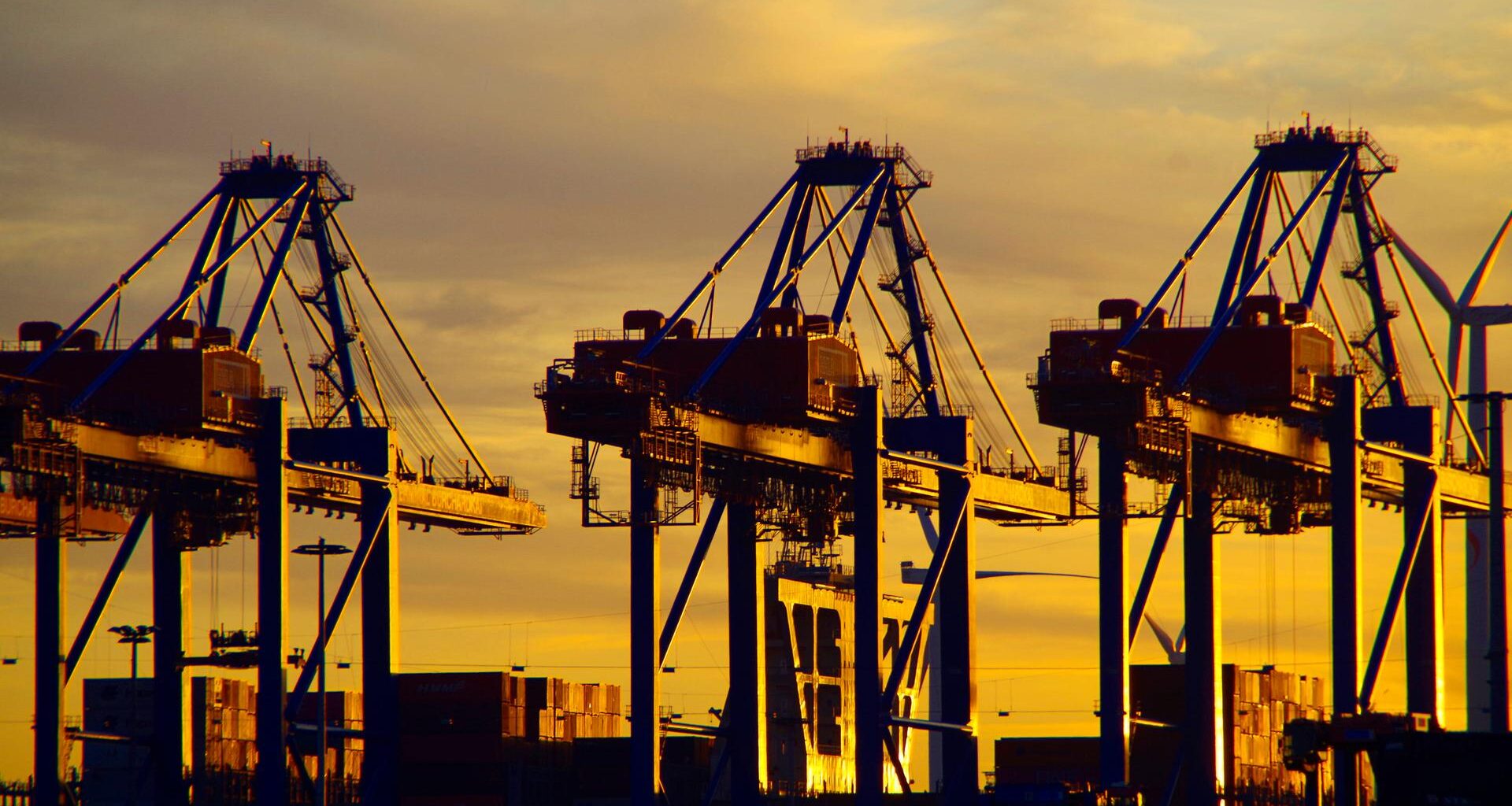 Containerbrücken im Sonnenuntergang im Hafen von Hamburg
