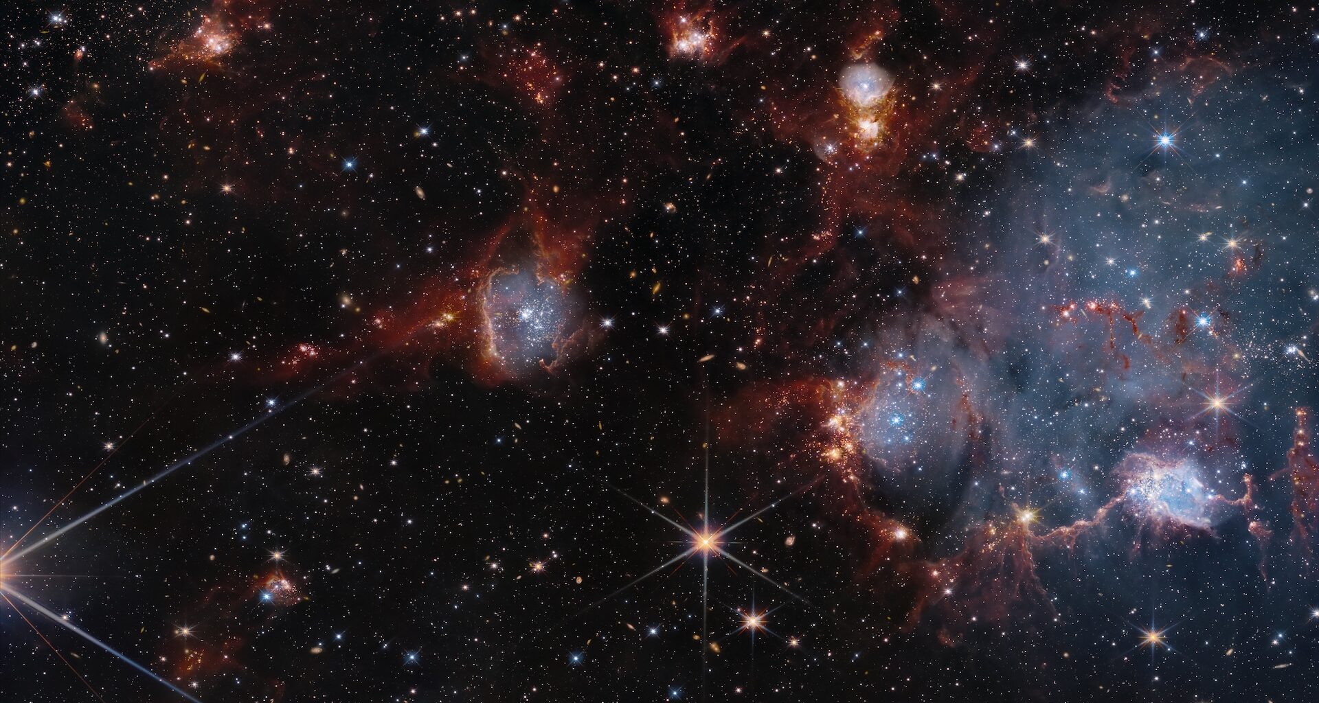 a photo of blue and orange cloudy shapes in outer space with countless twinkling stars
