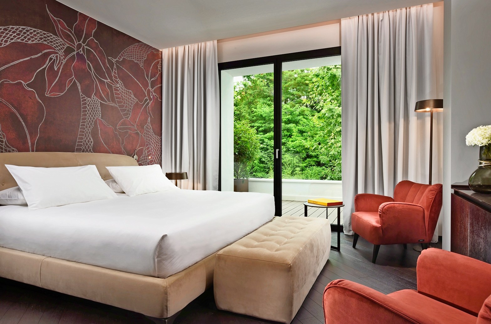 Hotel room with king-size bed and view of trees.