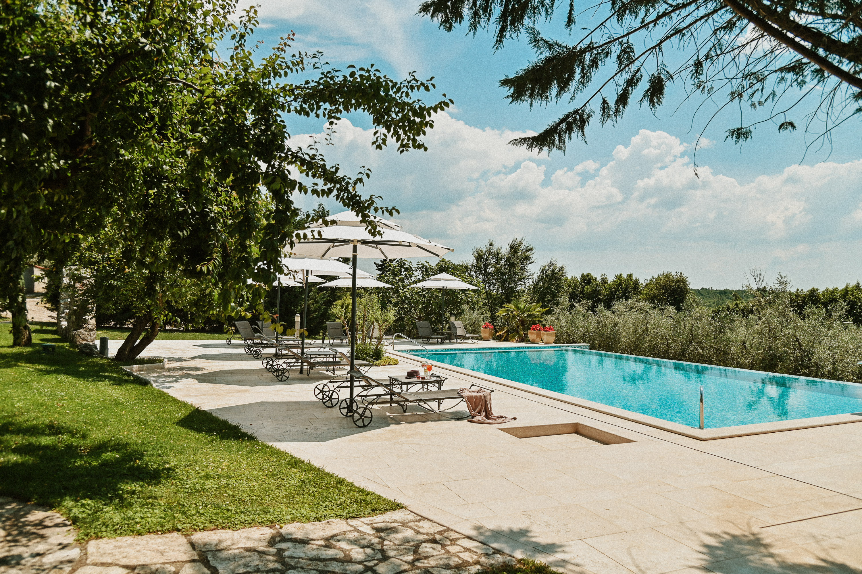 Hotel pool with lounge chairs and umbrellas.