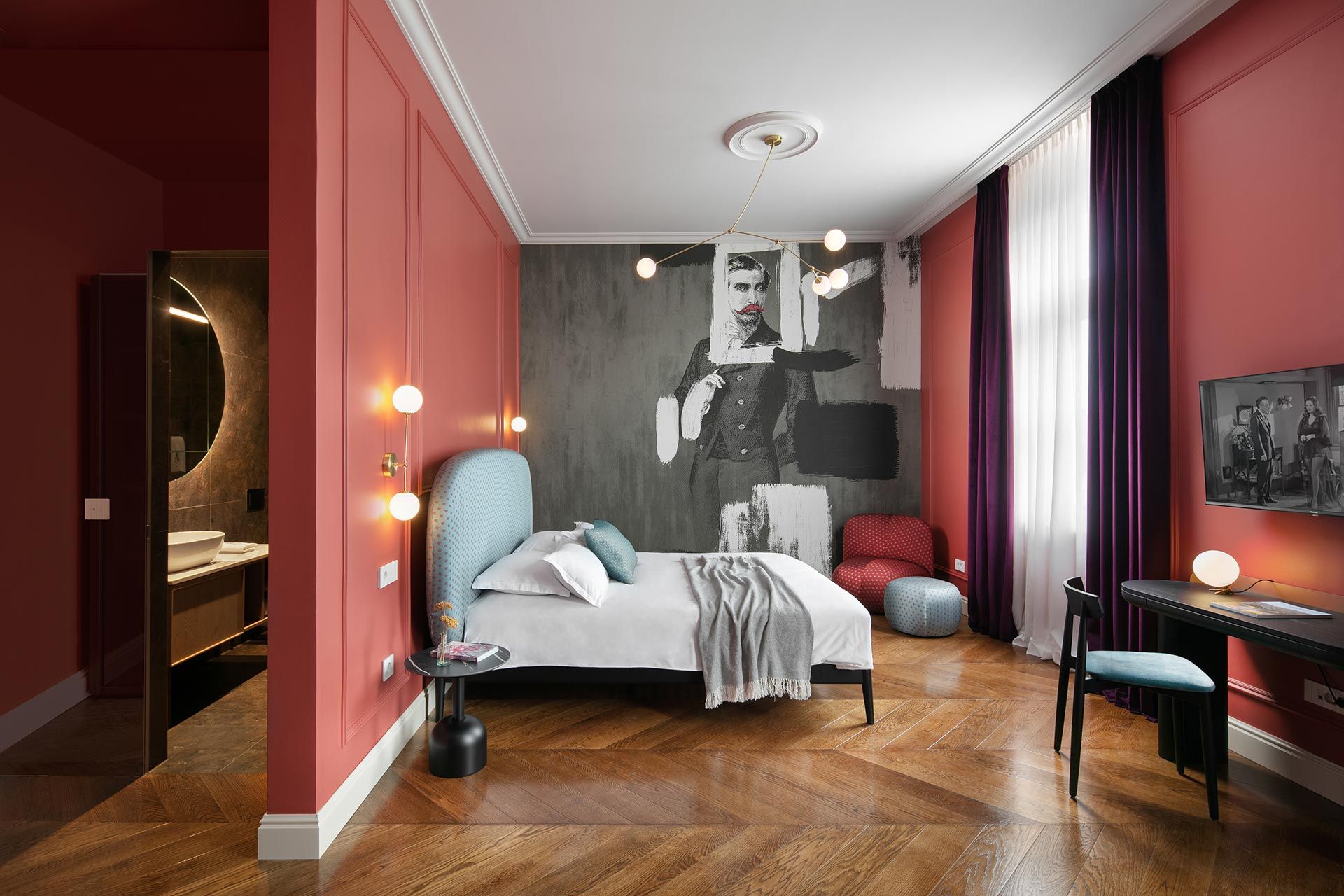Hotel room with a bed, artwork, and a desk.