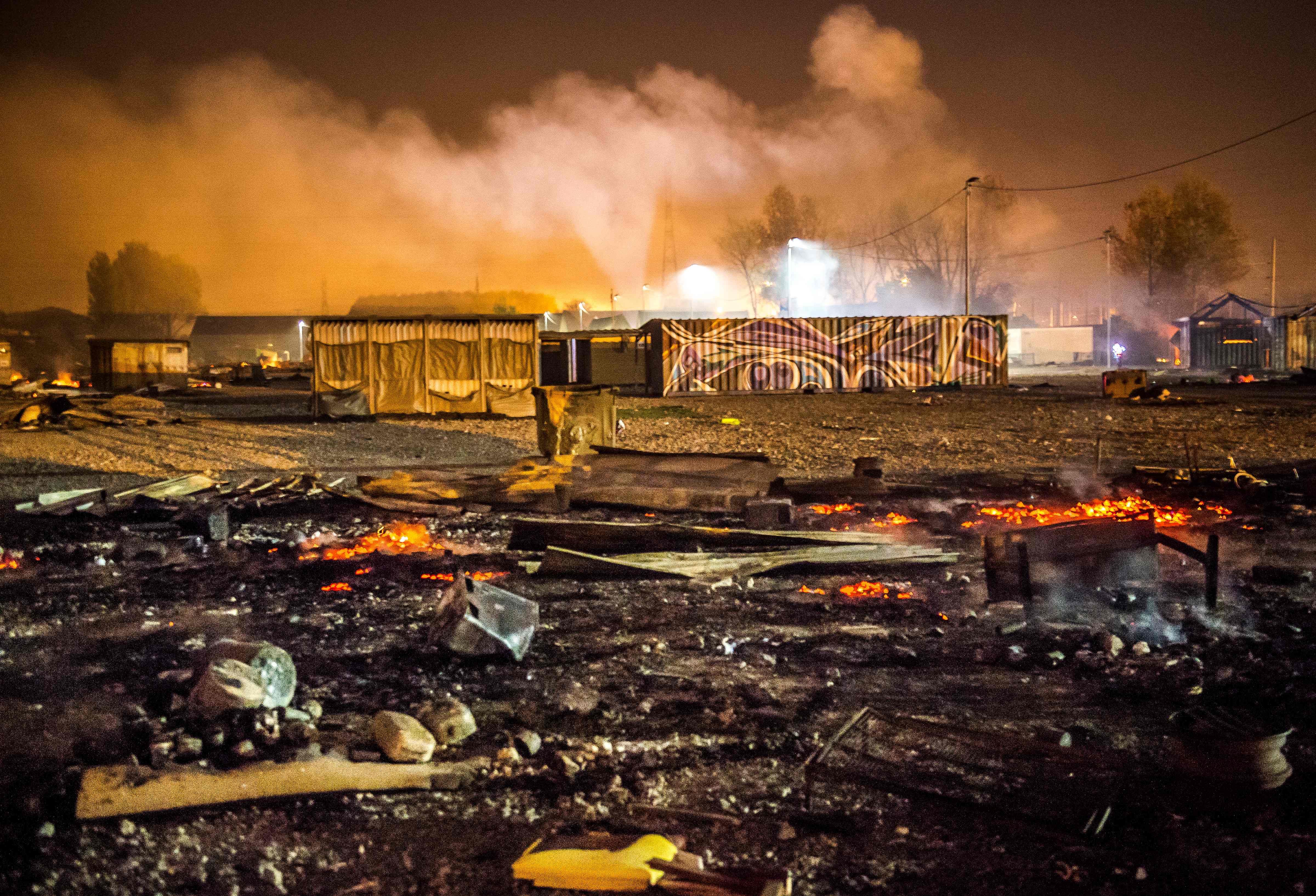 Burned-out Grande-Synthe migrant camp at night.