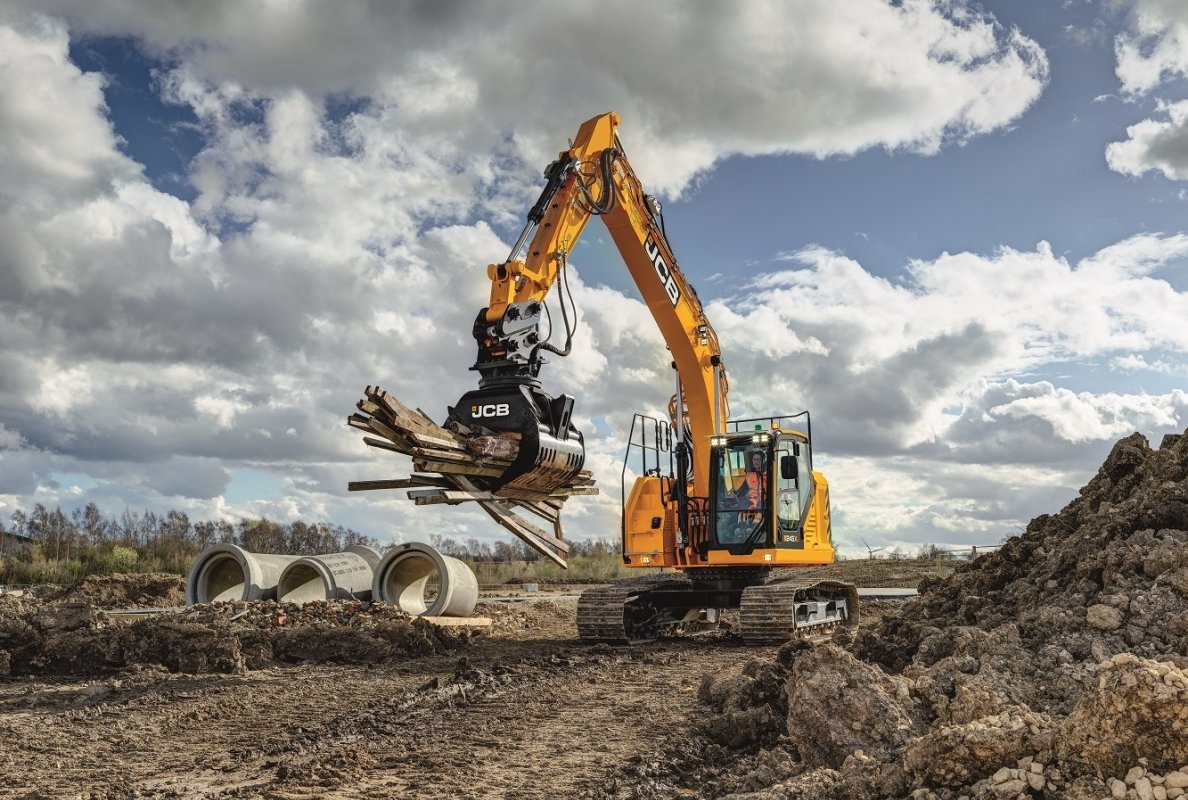 JCB 245XR reduced swing crawler excavator lifting scrap wood.