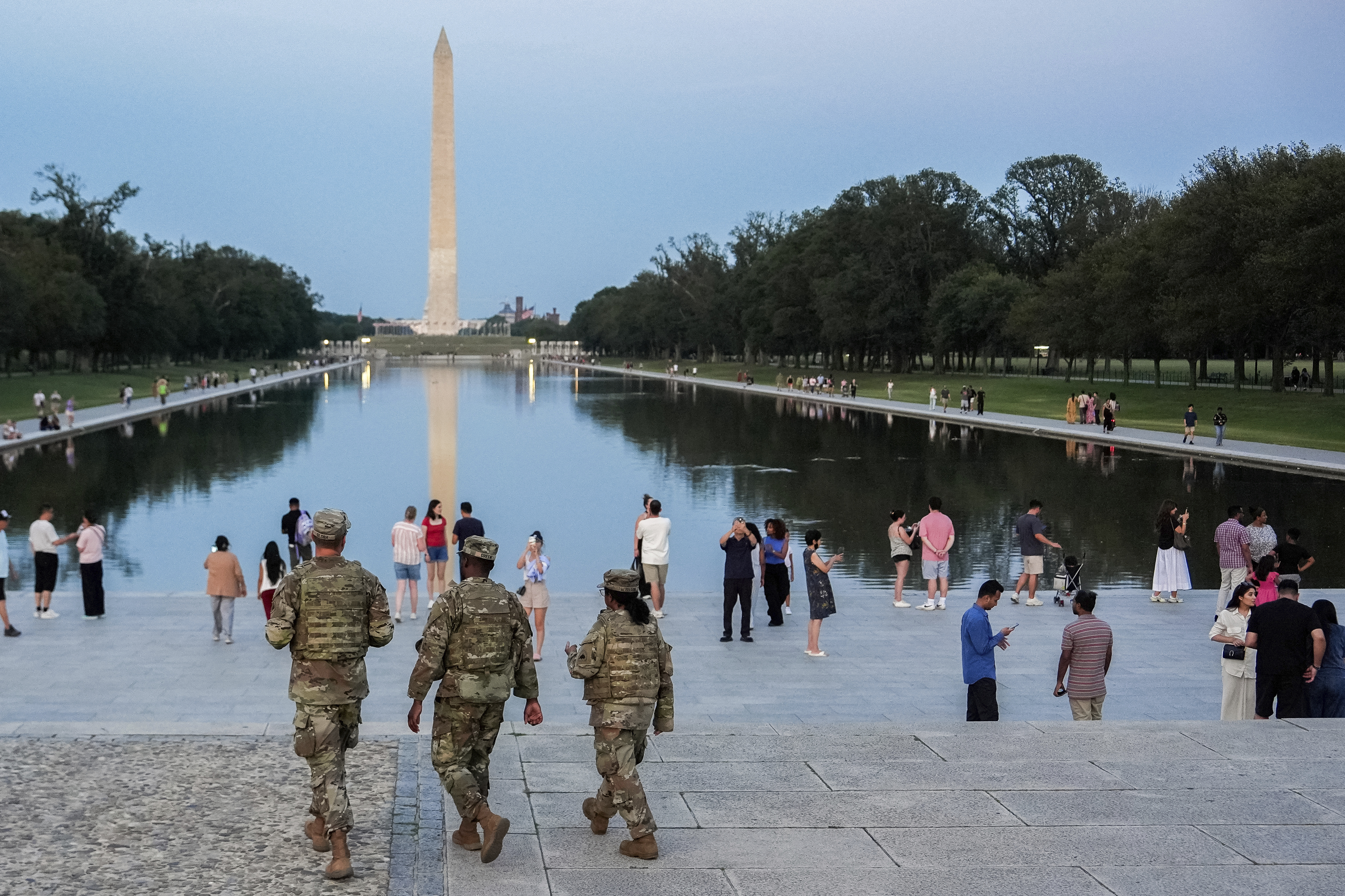 National Guard members patrol the National Mall in Washington, D.C., with the Washington Monument in the background.