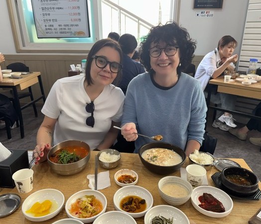 Two women eating Korean food in a restaurant.