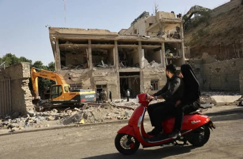 People ride on a motorcycle as a view shows the aftermath of an Israeli strike on Evin Prison that took place on June 23, after the ceasefire between Israel and Iran, in Tehran, Iran, June 29, 2025. (credit: MAJID ASGARIPOUR/WANA (WEST ASIA NEWS AGENCY) VIA REUTERS)