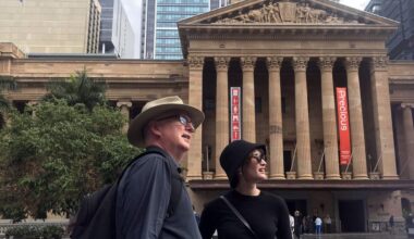 Two tour guides pass a museum in Brisbane, Australia.