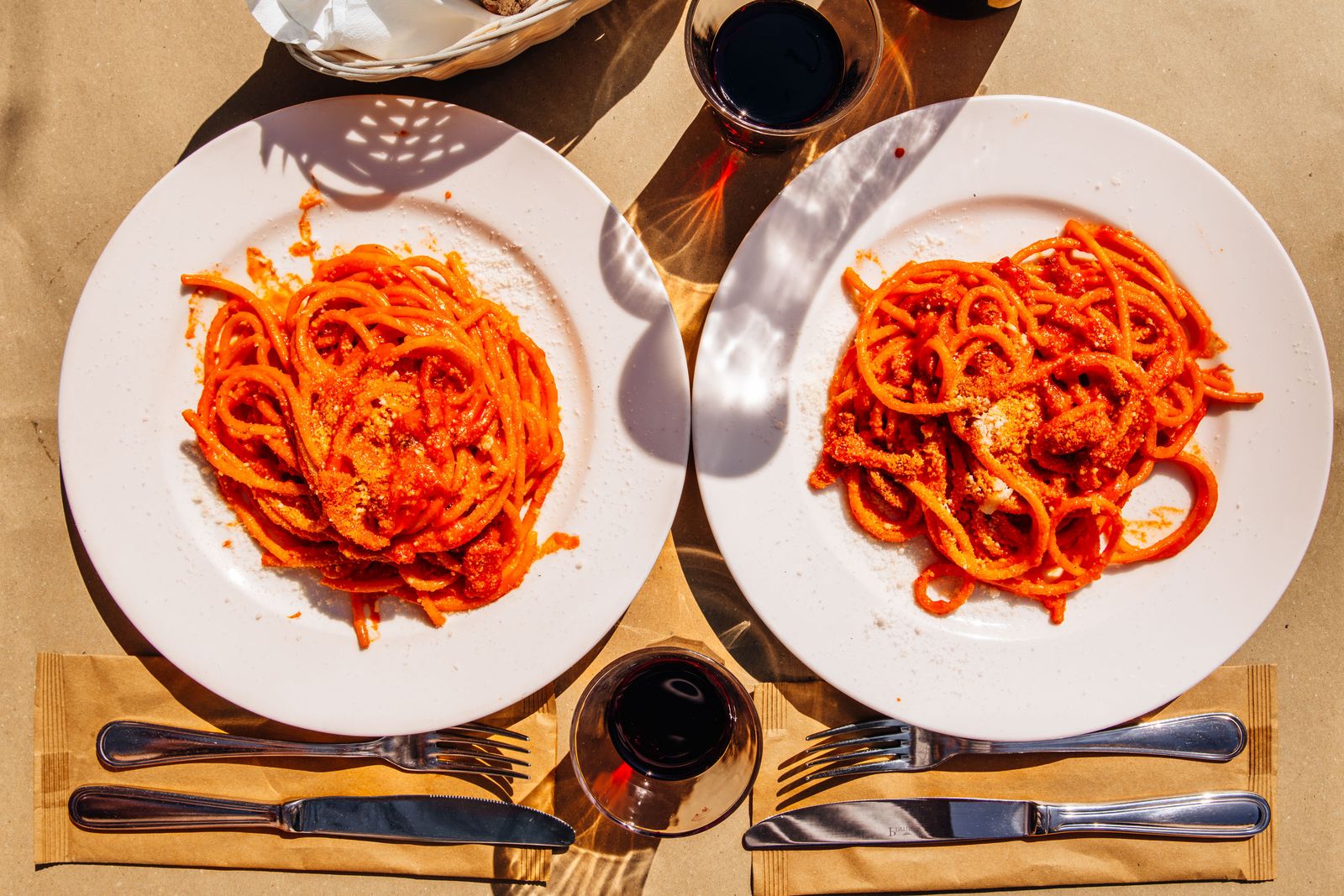 Above view of two plates of Pasta Amatriciana with tomato sauce and bacon