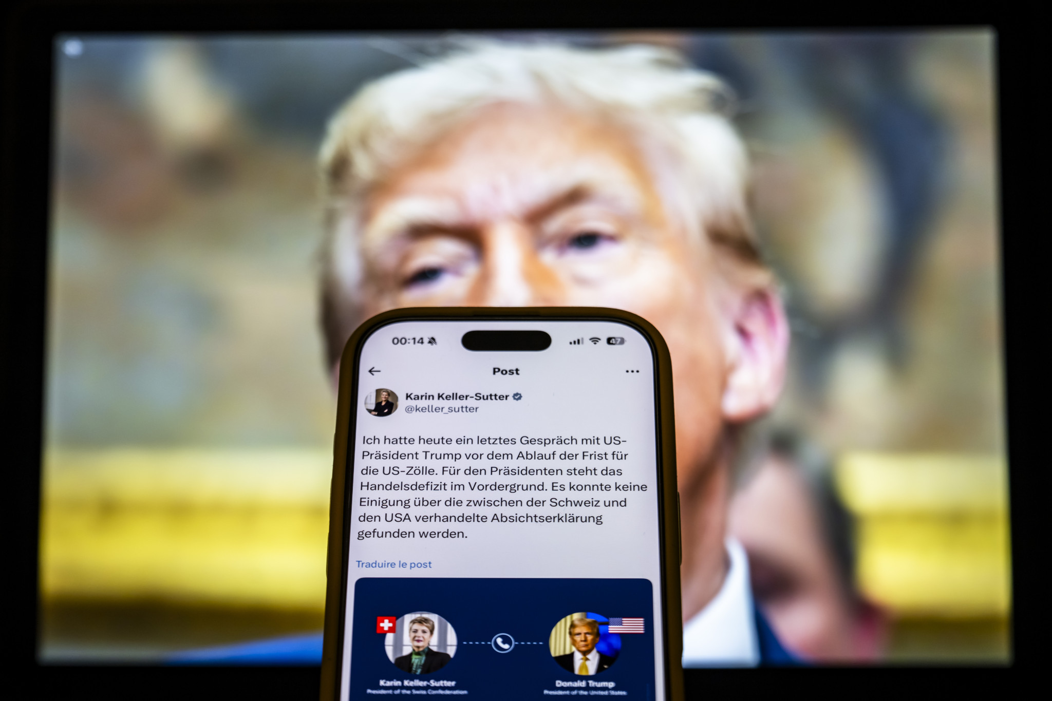 Un écran affiche une publication de réseau social sur un smartphone, avec un portrait flou d’un homme en arrière-plan. Un écran affiche une publication de réseau social sur un smartphone, avec un portrait flou d’un homme en arrière-plan.