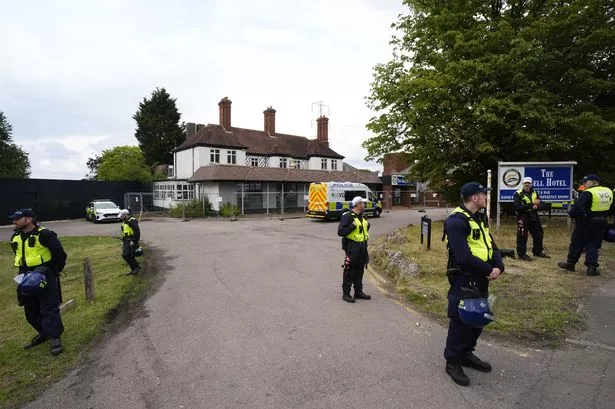 Police officers ahead of a demonstration outside the Bell Hotel in Epping