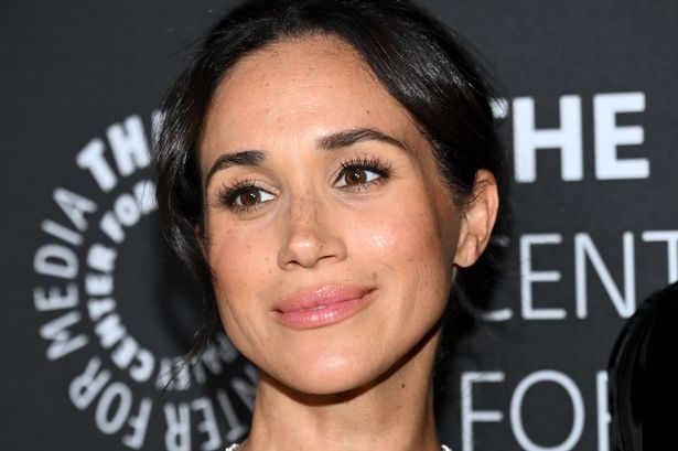 Meghan smiling in black dress at event
