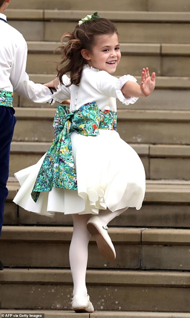 Bridesmaid Theodora (Teddy) Williams, daughter of Robbie Williams and Ayda Field, waves a she arrives to attend the wedding of Britain's Princess Eugenie of York to Jack Brooksbank