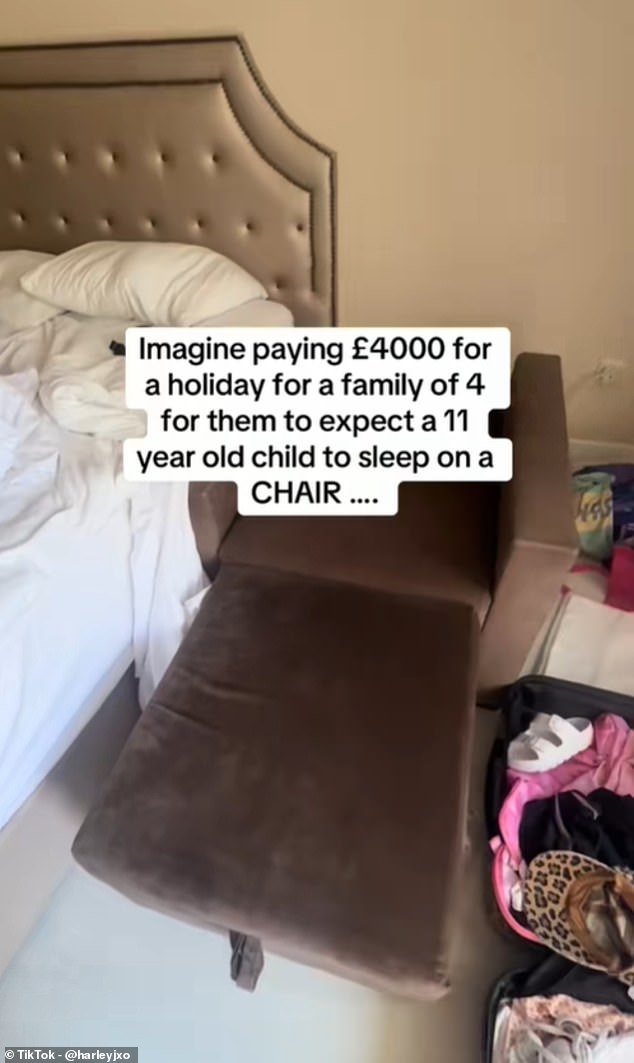 The mother demonstrated how the small, square-shaped brown chair transforms into a bed by pulling out a padded seat from its base and extending it to form a longer sofa