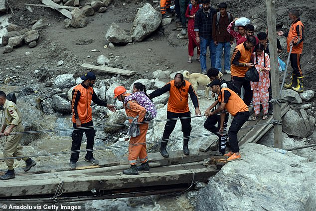A girl is being rescued near the site of cloudburst in Chositi village in Indian-administered Kishtwar, Jammu and Kashmir on August 15
