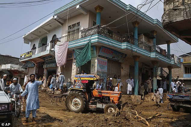 Most of the deaths, 328, were reported in the mountains of Khyber Pakhtunkhwa in northwestern Pakistan, according to the Provincial Disaster Management Authority. Pictured: Local residents clear the debris and mud from their shops after Friday's flash flooding on the outskirts of Pir Baba, Buner district