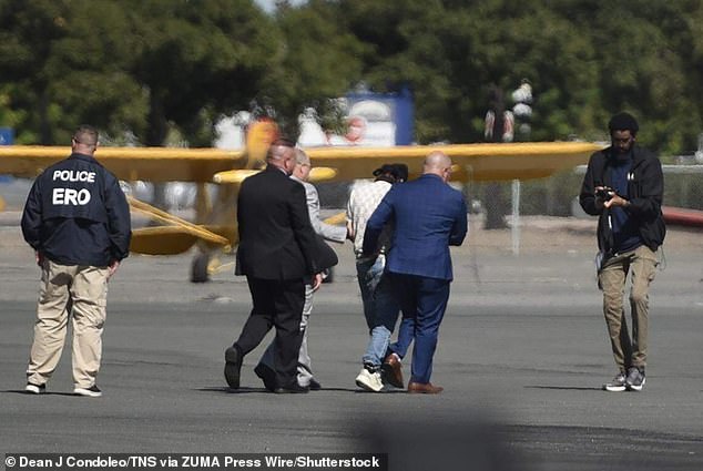 ICE officers and Florida Lt. Gov. Jay Collins escort Harjinder Singh toward a waiting plane at Stockton Metropolitan Airport for his extradition to Florida