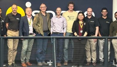 A group of people standing on a balcony, facing the camera