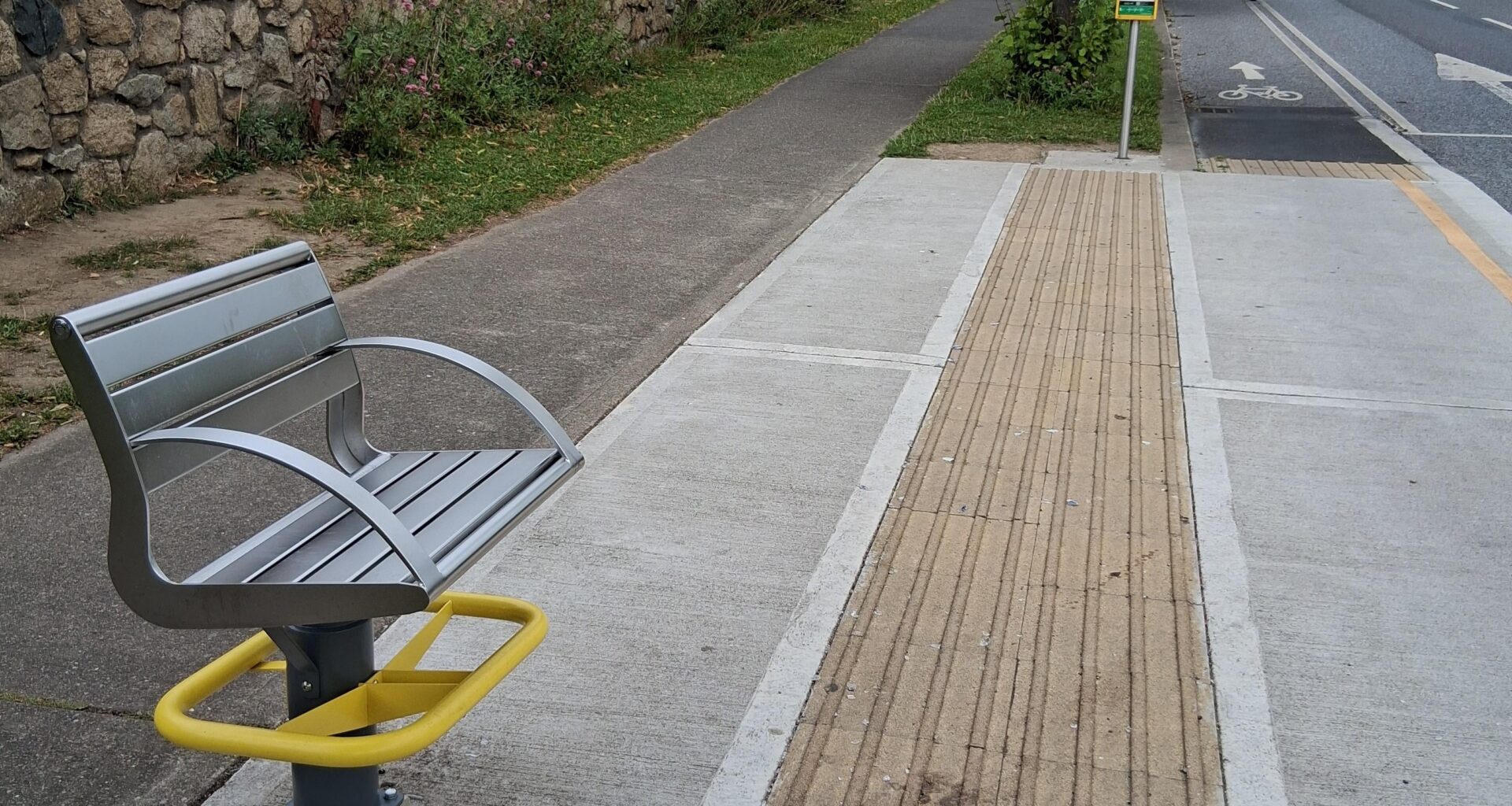This bus stop has a "bench" which provides seating for 1 person