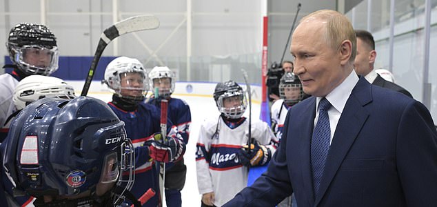 Russian President Vladimir Putin, right, shakes hands with young ice hockey players as he visits the Prezidentsky sports and recreation complex in Magadan, about 6,000 kilometers (3,700 miles) east of Moscow, Russia's Far East, on Friday, Aug. 15, 2025, on the way to Alaska. (Alexei Nikolsky, Sputnik, Kremlin Pool Photo via AP)