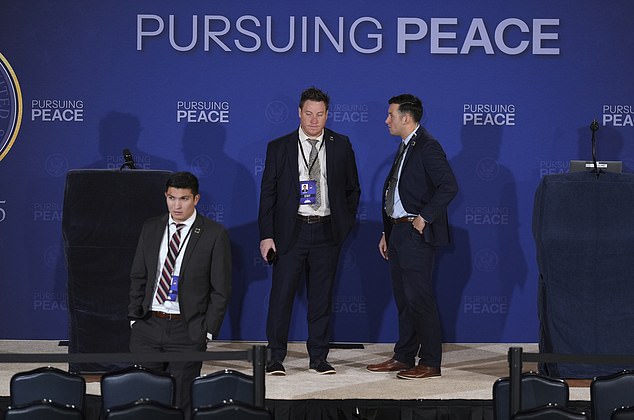 White House staff stand on the stage where President Donald Trump and Russia's President Vladimir Putin will participate in a joint press conference at Joint Base Elmendorf-Richardson, Alaska, Friday, Aug. 15, 2025. (AP Photo/Jae C. Hong)