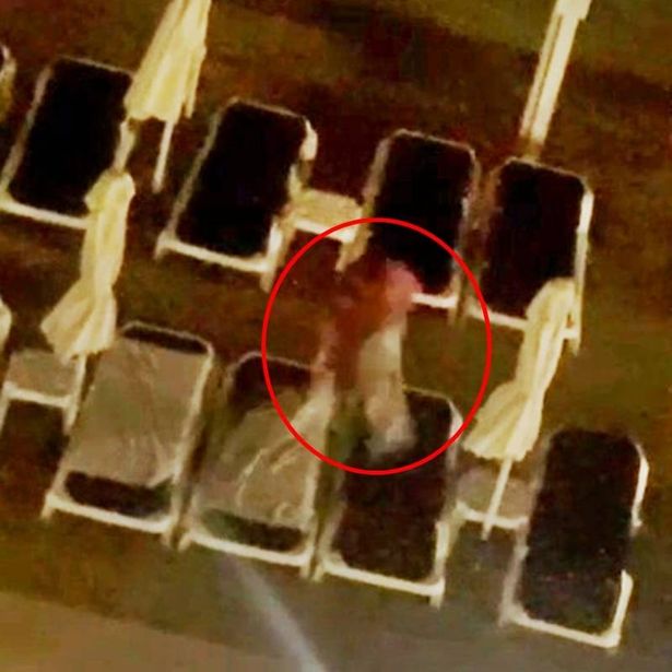 A woman removing towels from sunbeds