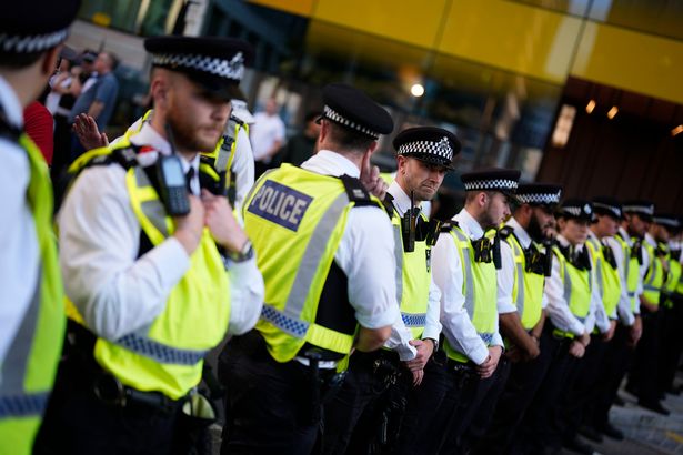 Lines of police officers separate the counter-protesters from those taking part in the Stand Up to Racism rally outside the Britannia International Hotel