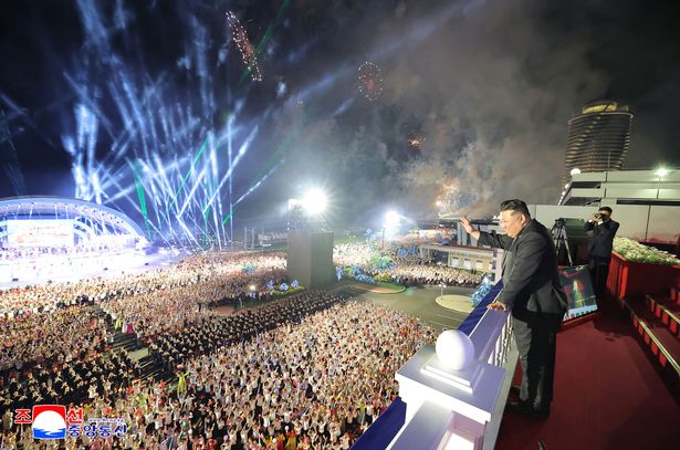 leader Kim Jong Un waving to the crowd at the opening ceremony of the Wonsan Kalma coastal tourist area