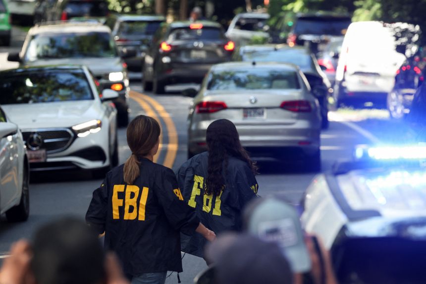 FBI members walk outside the home of the former White House national security adviser John Bolton in Bethesda, Maryland on August 22.