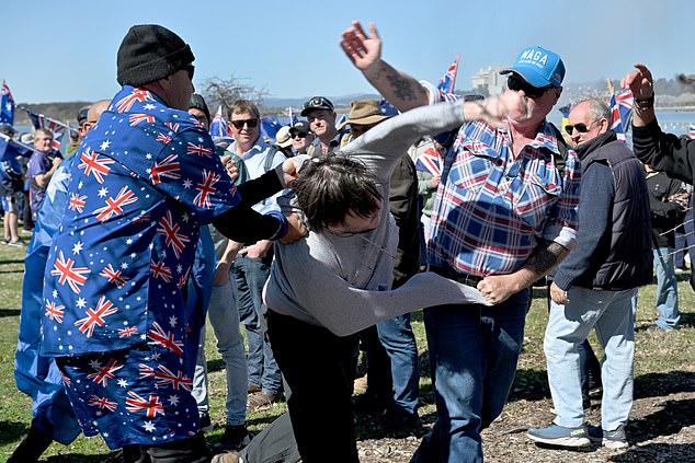 A anti fascist protester is restrained by anti immigration protesters during the March for Australia anti-immigration rally in Canberra, Sunday, August 31, 2025. (AAP Image/Mick Tsikas) NO ARCHIVING