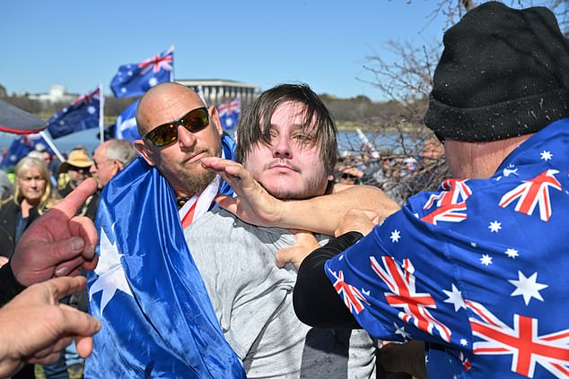 A anti fascist protester is restrained by anti immigration protesters during the March for Australia anti-immigration rally in Canberra, Sunday, August 31, 2025. (AAP Image/Mick Tsikas) NO ARCHIVING