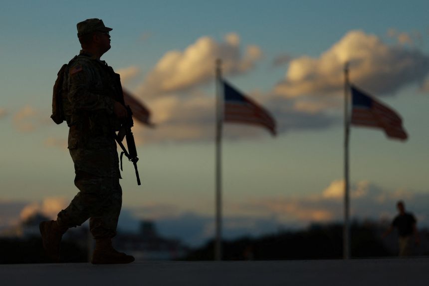 A member of the National Guard carries a firearm while patrolling the National Mall in Washington, DC, on Tuesday.