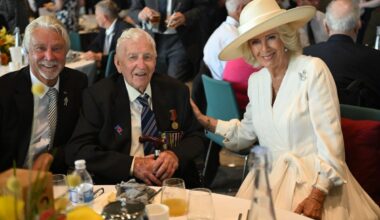 Queen Camilla speaks with Bob Gelder and his eldest son, Kim, during a reception for VJ veterans and their families hosted by the Royal British Legion in Staffordshire on August 15, 2025 (Eddie Mulholland/PA Images/Alamy)
