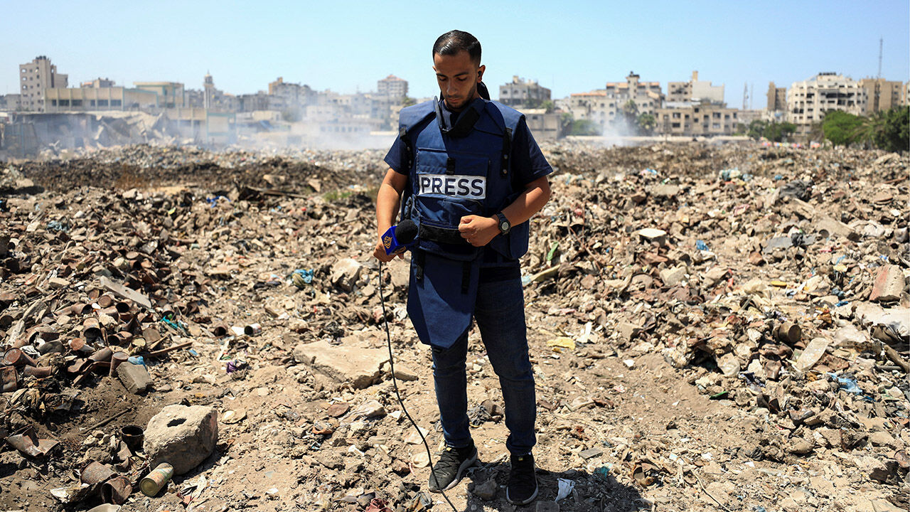Al Jazeera journalist Anas Al Sharif, who was killed in an Israeli strike on August 10, 2025, stands at a landfill as he reports the news in Gaza City August 13, 2024
