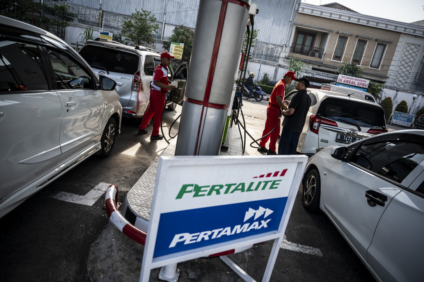 Attendants at a gas station owned by state-owned energy holding company Pertamina serve customers in Semarang, Central Java, on Feb. 27, 2025.