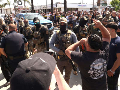 Residents confront federal and Border Patrol agents over a raid in their neighborhood on Atlantic Blvd. in the city of Bell, California, on June 19, 2025.