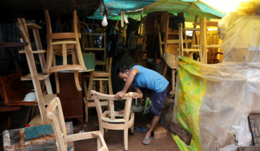 A man works on a chair at a shop in a furniture market in New Delhi on July 31, 2025.