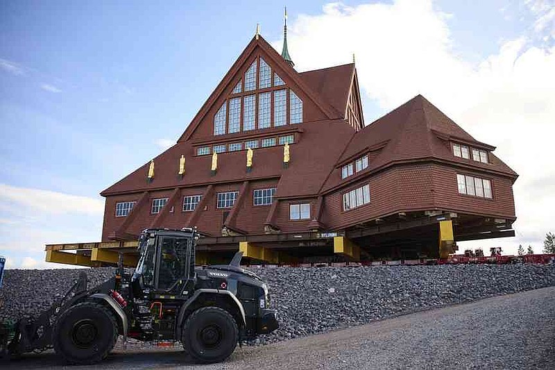 Construction machinery is parked next to the Kiruna Church, a Sami style wooden Swedish Lutheran church, called Kiruna Kyrka in Swedish, in Kiruna, Sweden, Wednesday, Aug. 20, 2025, after the completion of its move along a 5-km. (3-mile) route east to a new city center as part of the town's relocation.(AP Photo/Malin Haarala)