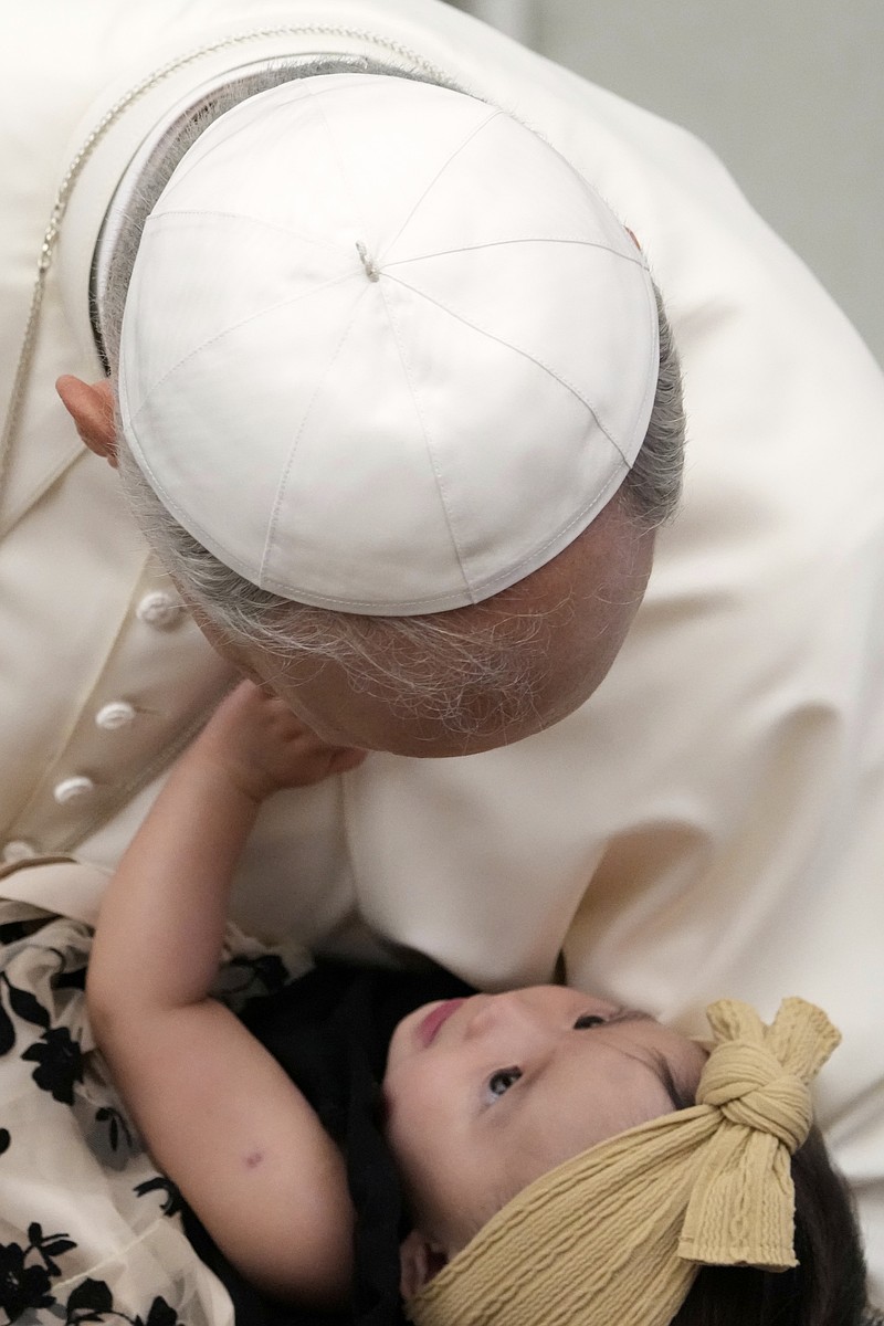 Pope Leo XIV holds a newborn during his weekly general audience at The Vatican, Wednesday, Aug.20, 2025. (AP Photo/Gregorio Borgia)