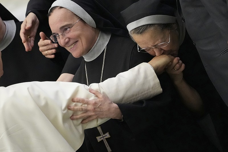 A nun kisses the hand of Pope Leo XIV during his weekly general audience, at The Vatican, Wednesday, Aug.20, 2025. (AP Photo/Gregorio Borgia)