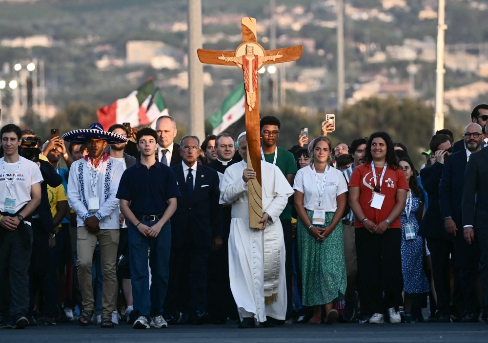 Pope Leo XIV (centre) holds the cross as he arrives in Rome's eastern Tor Vergata neighbourhood for a prayer vigil before Sunday Mass as part of the Jubilee of Youth, on August 2, 2025. — AFP pic