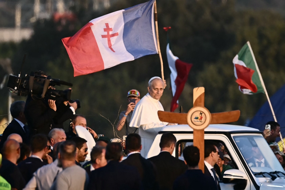 Pope Leo XIV (centre) greets the crowd in a papamobile as he arrives in Rome's eastern Tor Vergata neighbourhood for a prayer vigil before Sunday Mass as part of the Jubilee of Youth, on August 2, 2025. — AFP pic