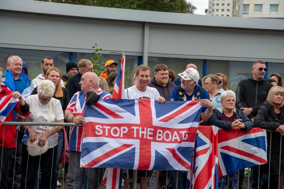 Protestors holding a "Stop the Boats" banner.