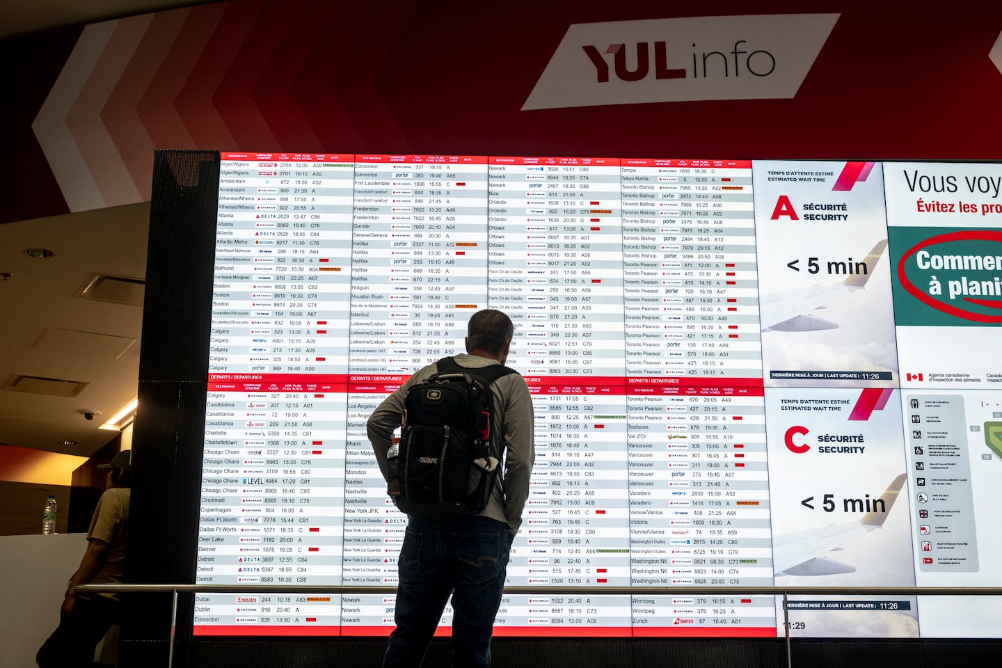 A person looked at a flight board with many cancellations for Air Canada flights at Pierre-Elliott Trudeau Airport in Montreal on Sunday.
