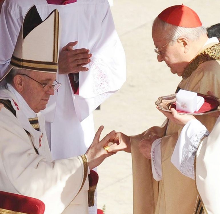 A cardinal cardinal puts the Fisherman's Ring, made of gold-plated silver, on a finger of Pope Francis during his inauguration mass, Vatican City, 19 March 2013 [File: EPA/Ciro Fusco]